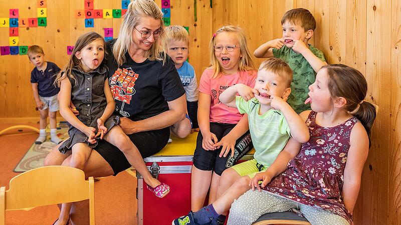 Kinder des Wiesenbronner Kindergartens sitzen albernd neben ihrer Kinderpflegerin Melanie Diaz Rivera. Kinder des Wiesenbronner Kindergartens sitzen albernd neben ihrer Kinderpflegerin Melanie Diaz Rivera.