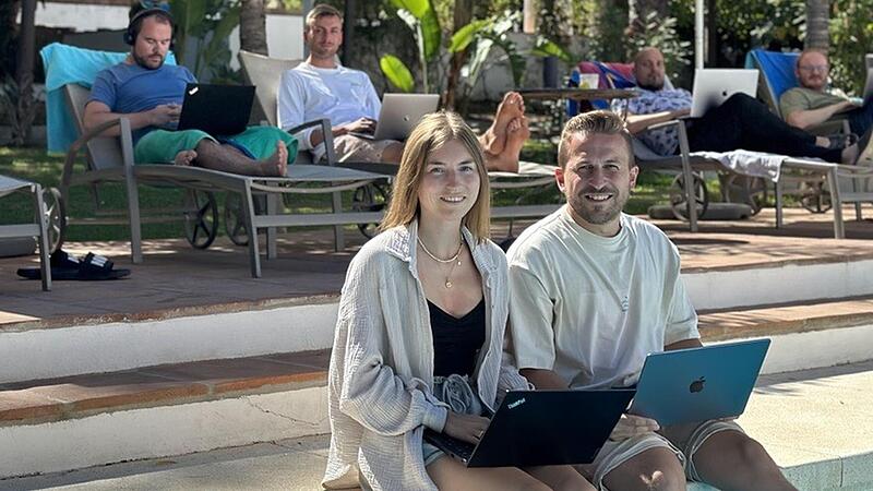 So l&auml;sst es sich leben &ndash; und arbeiten: Denise Neumeister und Riccardo Bonarrigo mit dem Laptop am Pool. Ihre Kollegen haben es sich im Hintergrund auf dem Liegestuhl bequem gemacht.