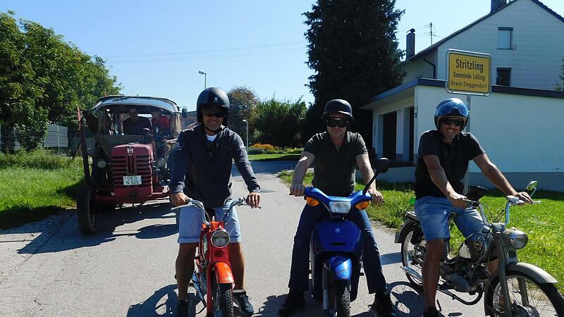 Sie geleiteten den fast 60 Jahre alten McCormick drei Tage lang in seine neue Heimat Franken: Andreas Berndl (v. l.), Sepp Stangl und J&uuml;rgen Schmid, hier beim Verlassen der Ortschaft Stritzling bei Lalling. Auf dem Traktor: Ano Engelhardt mit Sohn Anton.