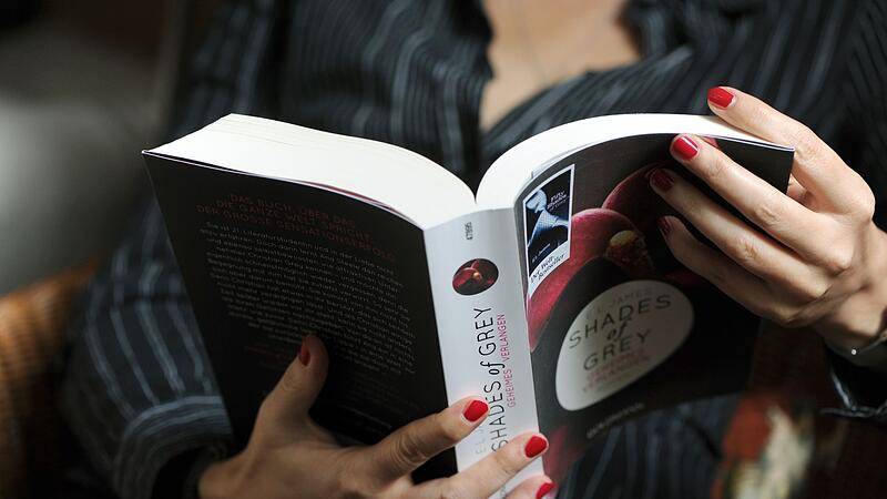 Eine Frau liest im Buch "Shades of Grey"