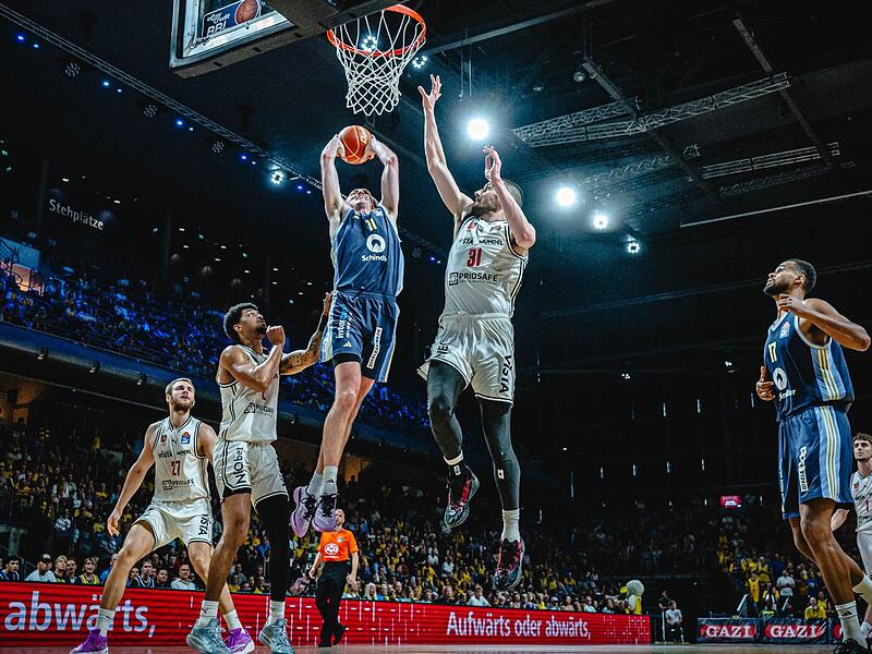 Der Berliner Power Forward Moses Wood fliegt ein. Ibi Watson (links) und Daniel Keppeler kommen zu sp&auml;t.