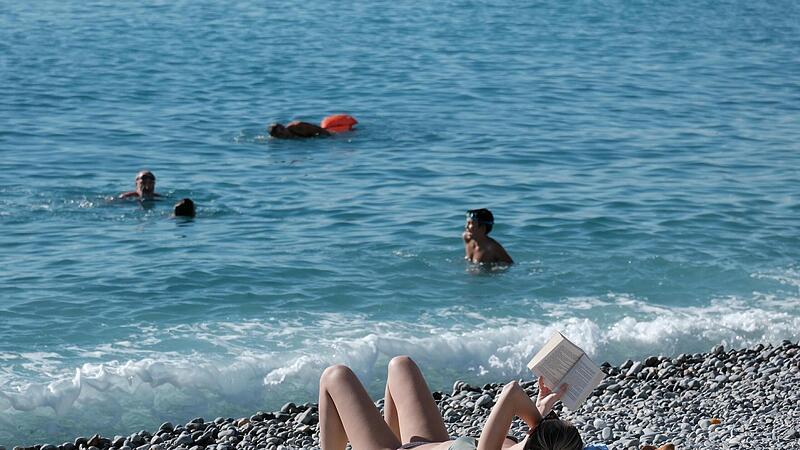 Menschen genie&szlig;en am Mittelmeer in Nizza die sommerlichen Temperaturen.  Fernreisen sind bei den Bayern aktuell nicht so angesagt.