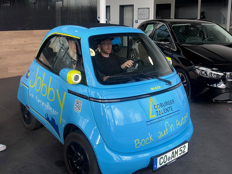 Zwei Azubis sitzen im Azubi-Mobil Jobby