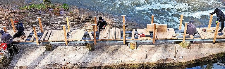 Wie ein Boot im wilden Strom: Mitarbeiter der Firma Eyrich-Halbig legten Planken auf den seit zwei Jahren nach einem Hochwasser gesperrten Steg im Staatsbad. Wie ein Boot im wilden Strom: Mitarbeiter der Firma Eyrich-Halbig legten Planken auf den seit zwei Jahren nach einem Hochwasser gesperrten Steg im Staatsbad.