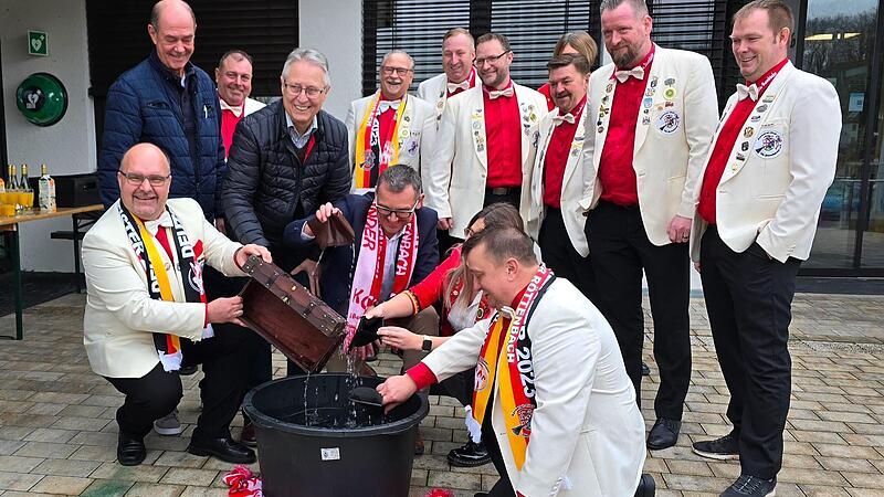 Die Narren der R&ouml;ttenbacher &bdquo;Besenbinder&ldquo; waschen ihre Geldbeutel zusammen mit dem B&uuml;rgermeister von R&ouml;ttenbach Ludwig Wahl (knieend zweiter von links).