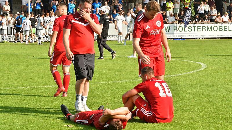 W&auml;hrend die Herzogenauracher Mannschaft im Hintergrund mit den Fans feiert, liegen die Lichtenfelser Spieler am Boden.