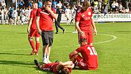 W&auml;hrend die Herzogenauracher Mannschaft im Hintergrund mit den Fans feiert, liegen die Lichtenfelser Spieler am Boden.