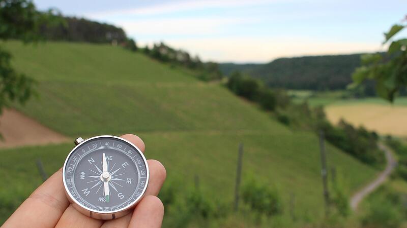 Mit dem Kompass ausgestattet durch malerische Landschaften wandern: Eine Escape-Tour, wie hier in Ramsthal, kann gleich doppelt Spa&szlig; machen.