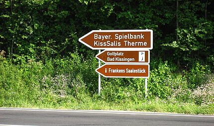 Das Foto zeigt einige der Schilder, die in der Vergangenheit an der Ausfahrt von W&uuml;rzburg kommend in Richtung Bad Kissingen zu sehen waren.