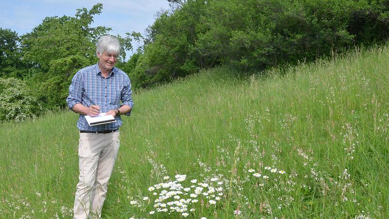 Werner Pilz erfasst die Pflanzenarten auf einem trockenen Wiesenstandort. Mehr als 20 stehen schon auf seinem Block.