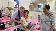 Gerhard Albert besucht den jungen Patienten Heinwan-o im Krankenhaus. Die Mutter des Buben, Rihun Nongtdu, bleibt immer an dessen Seite und schläft nachts unter seinem Bett.