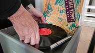 Eine LP wird behutsam auf den Plattenteller gelegt.