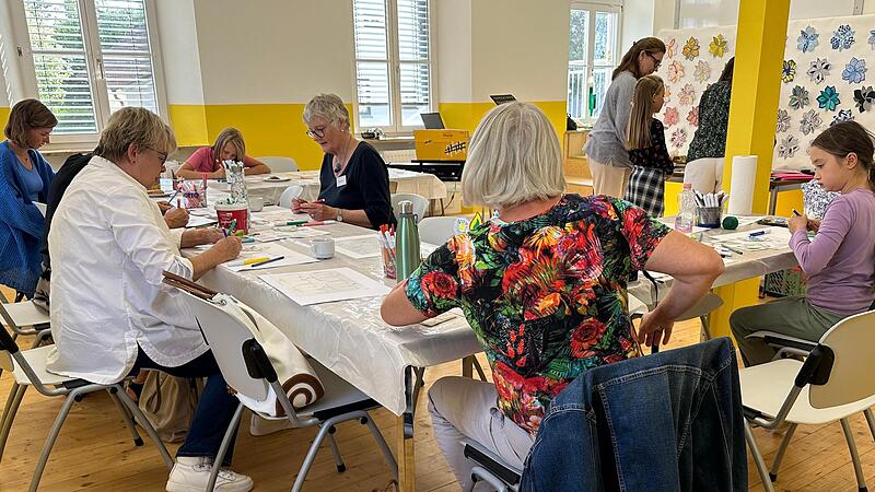 Während des musikalischen Rahmenprogramms bemalen die Hobbykünstler in Röttenbach hochkonzentriert Blüten.