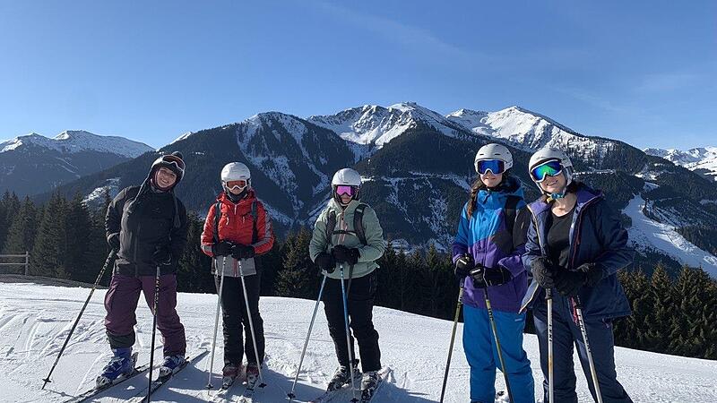 Jugendliche zusammen mit Skicampleiterin Anna Berenbold (links) beim Skifahren.
