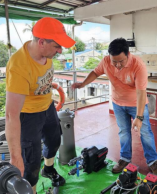 Klaus Str&auml;tz (links) pr&uuml;ft mit myanmarischen Helfern die Vollst&auml;ndigkeit der Bauteile.