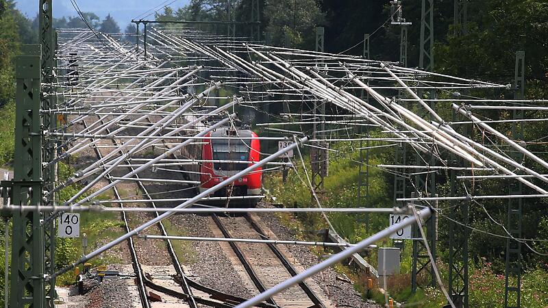 Eine Diesellok f&auml;hrt auf einer mit neuen Masten und Stromleitungen versehenen Bahnstrecke