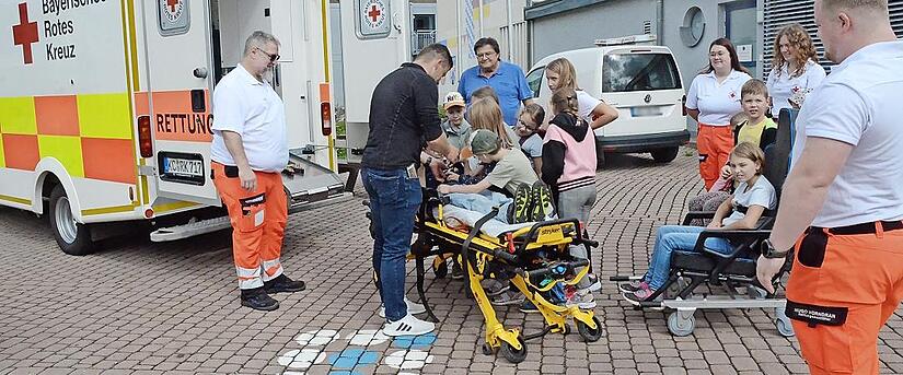 Die BRK-Lebensretter mit den vielen interessierten Kindern.