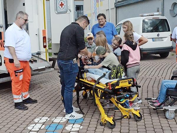 Die BRK-Lebensretter mit den vielen interessierten Kindern.