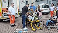 Die BRK-Lebensretter mit den vielen interessierten Kindern.