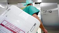 Ein Styropor-Behälter zum Transport von zur Transplantation vorgesehenen Organen wird am Eingang eines OP-Saales vorbeigetragen.