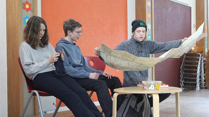 Helena (links strickend) ist eine der Schauspielerinnen. Sie muss im St&uuml;ck den Zauberw&uuml;rfel, das Spiel des Jahres 1980, l&ouml;sen. Sch&uuml;ler der Realschule Herzogenaurach f&uuml;hren es auf.