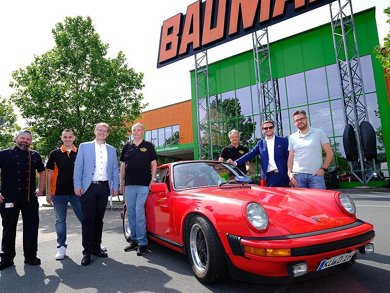 Automobile Ikonen, wie dieser luftgek&uuml;hlte Porsche 911, werden am 21. Juni beim Oldtimer-Treffen auf dem Globus-Gel&auml;nde zu sehen sein. Dar&uuml;ber freuen sich (von rechts) Tobias Sch&ouml;ffel, Landrat Jonas Gleich, Matthias Gro&szlig;, OSK-Vorsitzender Norbert ...