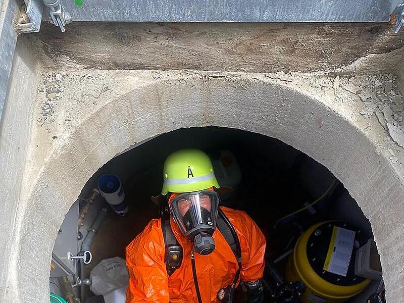Burgebrach: Gasaustritt sorgt für Feuerwehreinsatz an Hauptstraße Ein Feuerwehrmann steht mit Gasschutzausrüstung in einem Brunnenschacht in Burgebrach.