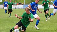 Bezeichnende Szene für Neukenroth aus dem Hinspiel gegen Rattelsdorf: Mit vollem Speed rutscht der Neukenrother Julius Wagner (grün) in den Laufweg des Rattelsdorfer Stürmers Jeffry Stade. Auch dieses Spiel im August hat die Lipfert-Elf verloren.