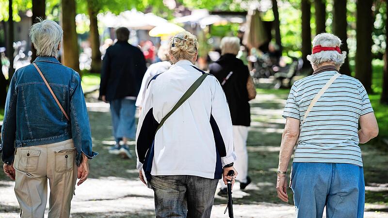 Frauen gehen bei einem Spaziergang gegen Einsamkeit f&uuml;r &auml;ltere Menschen durch einen Park.
