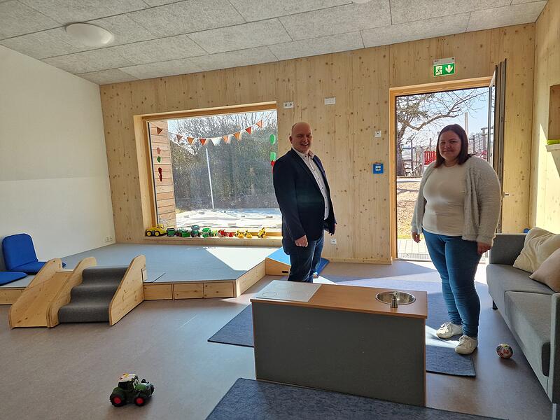 Helle R&auml;ume, bodentiefe Fenster und ein Holzpodest: B&uuml;rgermeister Daniel Wehner und Einrichtungsleiterin Laura Metz begutachten die neuen Krippenr&auml;ume der Kindertagesst&auml;tte in Burkardroth.