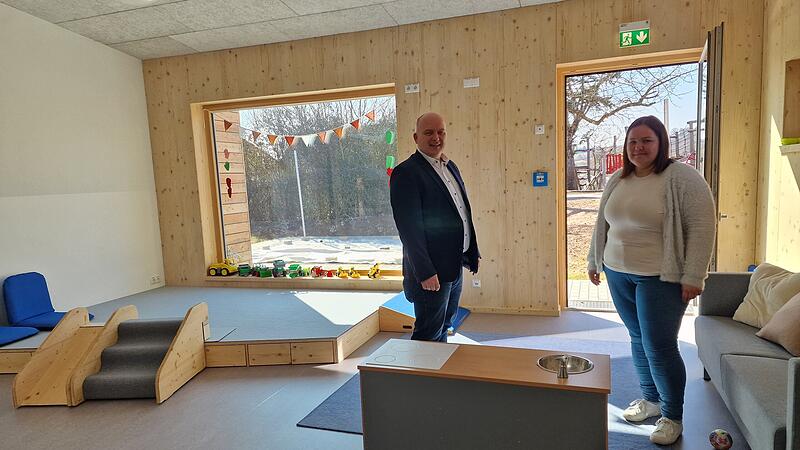 Helle R&auml;ume, bodentiefe Fenster und ein Holzpodest: B&uuml;rgermeister Daniel Wehner und Einrichtungsleiterin Laura Metz begutachten die neuen Krippenr&auml;ume der Kindertagesst&auml;tte in Burkardroth.