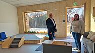 Helle R&auml;ume, bodentiefe Fenster und ein Holzpodest: B&uuml;rgermeister Daniel Wehner und Einrichtungsleiterin Laura Metz begutachten die neuen Krippenr&auml;ume der Kindertagesst&auml;tte in Burkardroth.