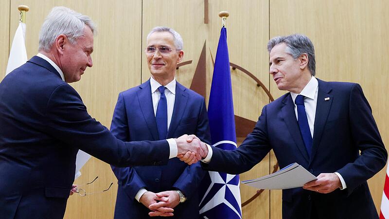Nato-Generalsekret&auml;r Jens Stoltenberg (Mitte) schaut zu, w&auml;hrend sich Pekka Haavisto (l.), Finnlands Au&szlig;enminister, und US-Au&szlig;enminister Antony Blinken die Hand geben.