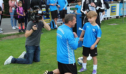 Der Weltmeister Lothar Matth&auml;us auf den Knien vor seinem Namensvetter Matth&auml;us "Matti" Haufen.