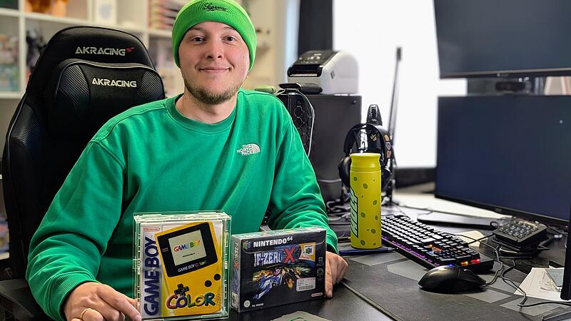 Ganz in gr&uuml;n: Jonas Steinbei&szlig;er alias der Fustler sitzt in seinem Streamingzimmer. Vor ihm stehen zwei seiner Lieblingssammelst&uuml;cke: ein originaler Gameboy-Colour und ein Videospiel.