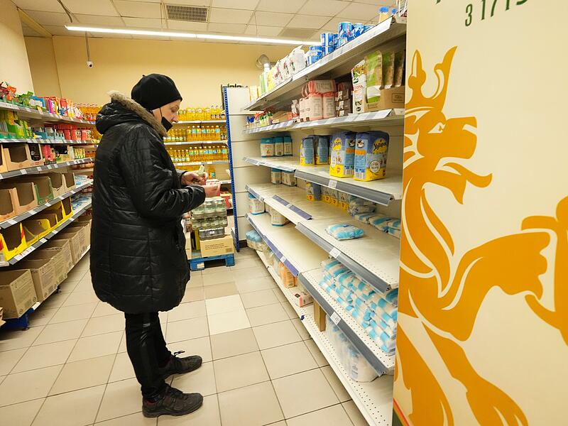 Ein Mann steht vor leeren Regalen in einem Lebensmittelgeschäft im ukrainischen Saporischschja. Russland hat am Donnerstag, 24.02.2022, einen umfassenden Angriff auf die Ukraine gestartet und Städte und Stützpunkte mit Luftangriffen oder Granaten beschossen.