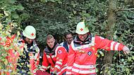 Helfer der SEG Technik und Sicherheit unterstützen ihre Kollegen der Rettungshundestaffel. Mit einer Rettungswanne wird ein Verletzter mit vereinten Kräften 150 Meter durchs Unterholz zum nächstbefahrbaren Weg getragen.