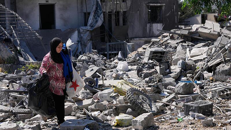 Aida Jleilati, die nach der Bekanntgabe einer vorläufigen Waffenstillstandsvereinbarung zwischen den Vereinigten Staaten und dem Iran in ihr Dorf zurückgekehrt ist, trägt ihre Habseligkeiten über die Trümmer ihres zerstörten Hauses. Aida Jleilati, die nach der Bekanntgabe einer vorläufigen Waffenstillstandsvereinbarung zwischen den Vereinigten Staaten und dem Iran in ihr Dorf zurückgekehrt ist, trägt ihre Habseligkeiten über die Trümmer ihres zerstörten Hauses.
