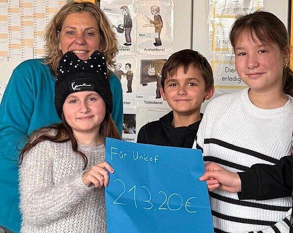 Kinder der 3. und 4. Klasse der Von-Lerchenfeld-Schule spendeten rund 216 Euro an das Kinderhilfswerk Unicef. Das Bild zeigt drei der Kinder mit Lehrerin Erika Fischer.