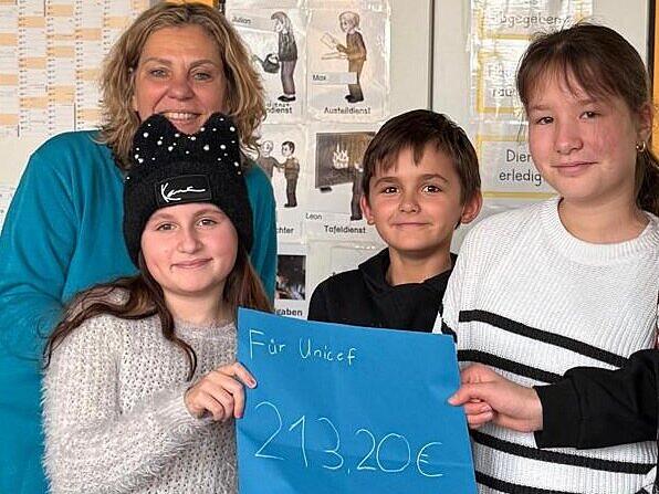 Kinder der 3. und 4. Klasse der Von-Lerchenfeld-Schule spendeten rund 216 Euro an das Kinderhilfswerk Unicef. Das Bild zeigt drei der Kinder mit Lehrerin Erika Fischer.