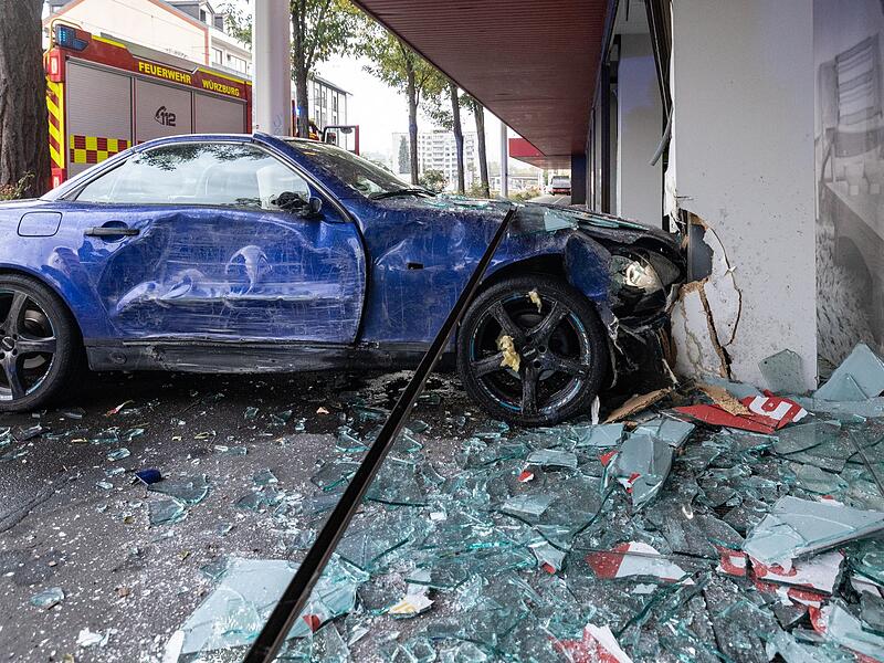 Frau fährt mit Auto in Möbelhaus-Schaufenster Frau fährt mit Auto in Möbelhaus-Schaufenster