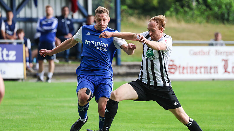 Mit einem langen Schritt versucht der Neufanger Lorenz Kotschenreuther (weiß) vor Mario Totzauer an den Ball zu kommen.