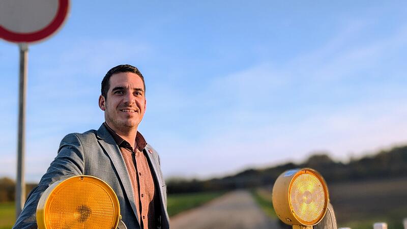 Maximilian Neeb, B&uuml;rgermeister der Stadt Se&szlig;lach steht vor einem Bauzaun.