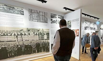 Einblick in die Ausstellung: NS-Gauleiter Julius Streicher (auf dem Ausstellungsfoto 6. v. r.) bei seinem Besuch 1934 im Diakonissen-Mutterhaus Hensoltsh&ouml;he (flankiert von Nazi-Funktion&auml;ren und der Heimleitung).