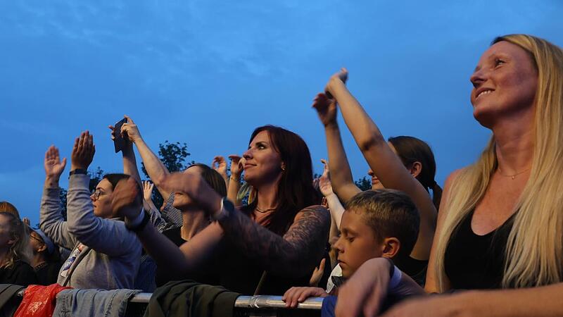Begeisterte und m&uuml;de Fans genie&szlig;en Songs am Sommerabend.
