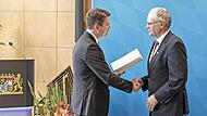 Roland Limpert erhält von Sandro Kirchner die Verdienstmedaille bei einer Feierstunde in Würzburg.