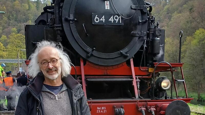 Der Bad Brückenauer Autor Dirk Hönerlage, Verfasser des Romans „Unter Dampf“, vor einer Dampflokomotive.