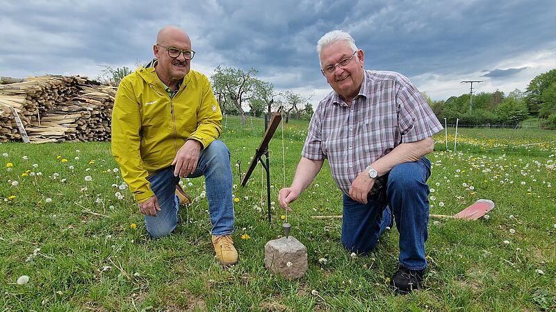 Das Werkzeug der Feldgeschworenen: Walter Muth (links) und Siegfried Schaub demonstrieren das Setzger&auml;t mit Senklot an einem Grenzstein.