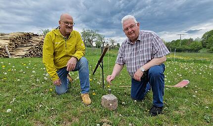 Das Werkzeug der Feldgeschworenen: Walter Muth (links) und Siegfried Schaub demonstrieren das Setzger&auml;t mit Senklot an einem Grenzstein.