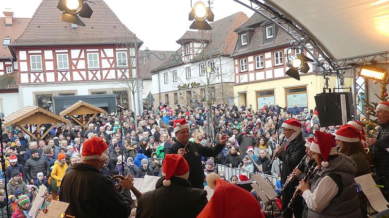 Die Zuschauer auf dem Marktplatz lauschen den ehemaligen Mitgliedern der Stadtjugendkapelle.